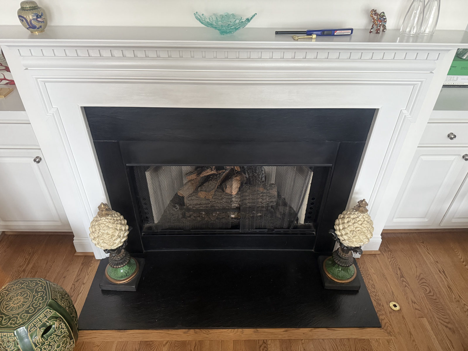 White mantel gas fireplace with decorative urns and built-in cabinetry — Holly Springs, NC
